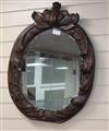 An early 19th century oval carved wall mirror                                                                                          