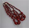 Two graduated simulated cherry amber bead necklaces, including one double strand, gross weight 129 grams, both approx. 48cm.           