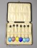 A late 1920's cased set of six continental silver and enamel bean end coffee spoons, import marks for George Stockwell, London, 1929, 9.9cm.                                                                                