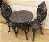 Two cast iron garden chairs and a table W.59cm (table a.f.)                                                                            