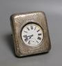 An early 20th century hammered silver mounted travelling watch case, marks rubbed, with keyless Goliath pocket watch.                                                                                                       
