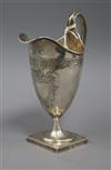 An antique white metal helmet shaped cream jug, on square foot, 19.3cm.                                                                