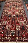 A Baktiari brick red ground rug 360 x 152cm                                                                                            