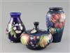 Two Moorcroft vases in 'clematis' and 'pansy' and a similar 'leaf and berry' jar and cover, 1920/30's, H.12.5cm - 18cm                 