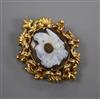 A Victorian yellow metal mounted chalcedony cameo brooch, the carving incorporating three classical faces and a ram's head, 35mm.      