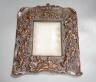A bronzed copper frame decorated with putti, circa 1900. 28.5cm long                                                                                                                                                        