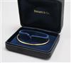 A Tiffany & Co 18ct gold bangle, with Tiffany & Co boxes.                                                                              