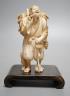 A Japanese ivory figure of a farmer smoking a pipe, Meiji period, signed - 12cm tall                                                                                                                                        
