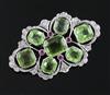 A mid 20th century pierced white gold, peridot, ruby and diamond set shaped oval brooch, gross 10.3 grams.                             