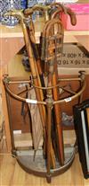 Six walking sticks, a shooting stick and an umbrella stick stand                                                                       