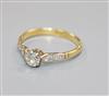 An 18ct gold and single stone diamond ring with diamond set shoulders, N/O.                                                            