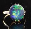 A 1920's 18ct gold, platinum and oval black opal dress ring with diamond set shoulders, size M.                                        