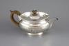 A George III demi-fluted silver squat circular teapot, by Robert & Samuel Hennell                                                                                                                                           