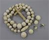 An ivory bead necklace, a carved cross and three pairs of earrings.                                                                    