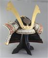 Japanese movie interest: A reproduction of a Japanese Samurai helmet (Kabuto), with ebonised box, helmet approximately 41.5cm wide     