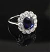 A white metal, sapphire and diamond oval cluster ring size M.                                                                          