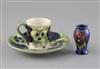 A Moorcroft 'pansy' pattern coffee cup and saucer, c.1915 and a similar later miniature vase, H.5.1cm                                  