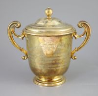 An Edwardian silver gilt-lidded two handled presentation cup and cover, by R & S Garrard and Co.                                       