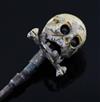 A 19th century French? base metal and cream enamel skull head stick pin, in the manner of Trouve & Cadet-Picard, overall 73mm.         