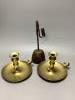 A pair of Regency brass ejector chambersticks (lacking snuffers) and an early 19th century wrought iron rushlight holder                                                                                                    