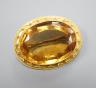 A Victorian yellow metal and citrine set oval brooch, with cannetille work border, 35mm, gross weight 11.3 grams.                                                                                                           