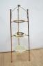 A W.A.S Benson brass and copper three tier stand, with two Vaseline glass dishes (upper dish lacking) 60 cms high.                                                                                                          