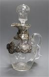 An Edwardian silver mounted glass claret jug & stopper, William Comyns, London, 1909 and two wine labels, one silver.                  