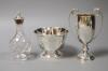 A small circular silver footed bowl, a two-handled silver trophy cup and a cut glass bottle                                                                                                                                 