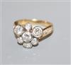 An 18ct and seven stone diamond cluster ring, with diamond set shoulders, size K/L.                                                    