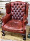 A George II style red leather buttoned wing armchair, ball and claw feet                                                               