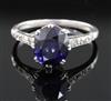 A mid 20th century platinum? and single stone oval synthetic sapphire ring, size M.                                                    