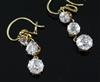 A pair of gold and graduated three stone diamond set drop earrings, 22mm.                                                              