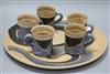 An Usch Spettigue pottery wall plaque and a set of five mugs, diameter 45.5cm                                                          