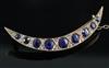 An Edwardian gold, graduated sapphire and rose cut diamond set crescent brooch, 5cm.                                                   