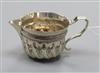 A late Victorian silver embossed cream jug, London 1885,                                                                               