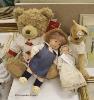 A modern Kathe Kruse doll with Burlington Berties cot and modern china baby doll and Harrods bear                                                                                                                           