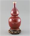 A Chinese sang de boeuf double gourd vase, 19th century H. 25cm, wood stand                                                            