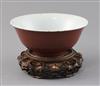 A Chinese copper red glazed bowl, Qianlong seal mark and of the period (1736-95), D. 18.2cm, small rim chips, wood stand               