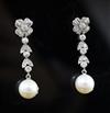 A pair of mid 20th century white metal, cultured pearl and diamond cluster set drop earrings, 33mm.                                    