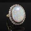 An 18ct gold, white opal and diamond oval cluster ring, size N.                                                                        