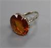 A white metal and oval cut citrine ring with diamond set shoulders, size K.                                                            