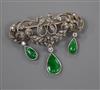 A 1920's yellow metal, diamond and jadeite set drop openwork scroll brooch, width 38mm.                                                