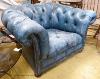 Victorian style, buttoned blue leather chesterfield armchair.                                                                                                                                                               