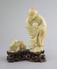 A Chinese soapstone group of a luohan and a lion dog, possibly 17th/18th century, 22.5 cm height including card wood stand                                                                                                  