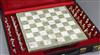 A cased 1960's chess set with a white and green marble chess board and thirty two 9ct gold chess pieces, in white and yellow gold,     