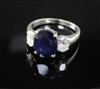 An 18ct white gold sapphire and diamond three stone dress ring, size O/P.                                                              