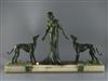 P. Huguenot. An Art Deco bronze and three coloured onyx group of a medieval lady and two hounds, width 28.5in. height 17.25in.         