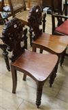 A pair of William IV carved mahogany hall chairs                                                                                       