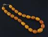 A single strand graduated ovoid amber bead necklace, 38cm.                                                                             