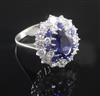 A modern 18ct white gold, sapphire and diamond oval cluster dress ring, size O.                                                        